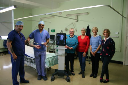 A photograph of theatre department staff accepting the ultrasound machine off four members of the League of Friends of Louth Hospital