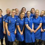 A group photograph of new midwives smiling in uniform