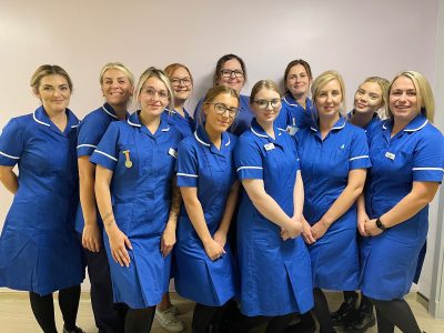 A group photograph of new midwives smiling in uniform