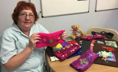 Hazel Smith, housekeeper on Burton ward with the knitted fiddleblankets and fiddlemuffs