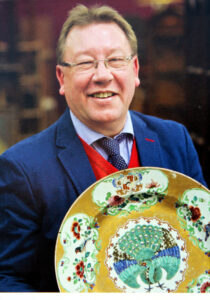 A man holding a large decorative plate