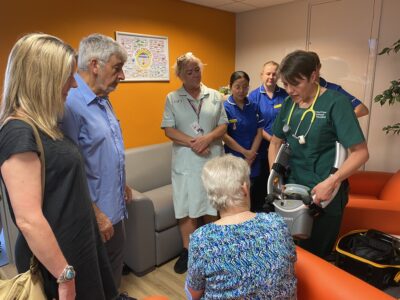 Maureen, Zoe and Robert being shown the LUCAS device