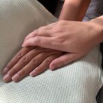 A relative holding a patient’s hand