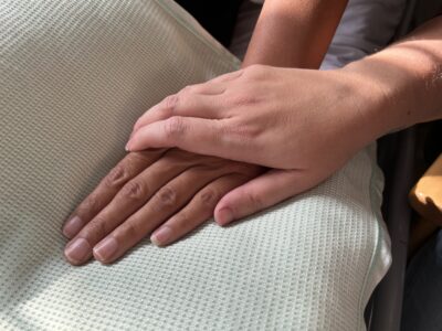 A relative holding a patient’s hand