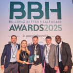 A group of people stand holding a trophy in front of a large BBH Awards 2025 sign.