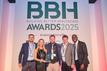 A group of people stand holding a trophy in front of a large BBH Awards 2025 sign.