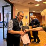 lady giving a man a small paper gift bag