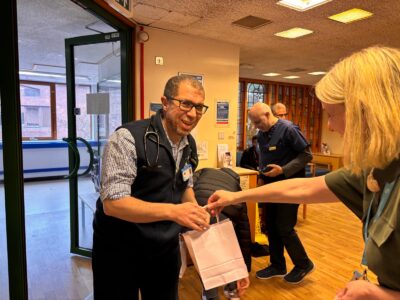 lady giving a man a small paper gift bag