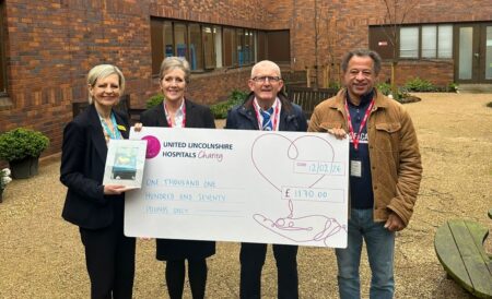 four people stood with a giant cheque