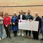 six people stood with a big cheque