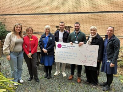 six people stood with a big cheque