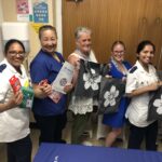nurses holding grey bags with flower on cover