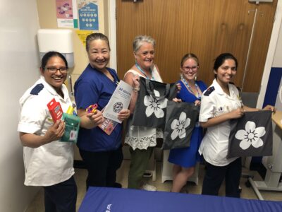nurses holding grey bags with flower on cover