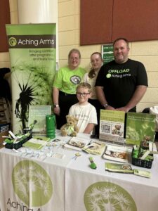 two people and two children stood behind a desk with leaflets 